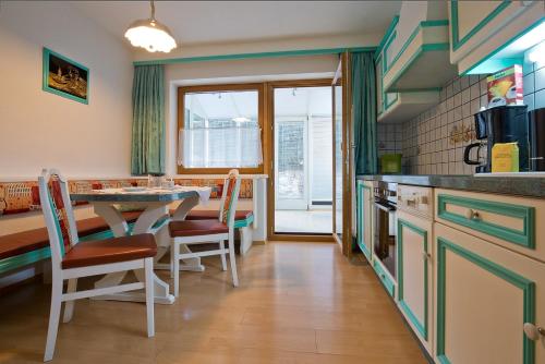 Una cocina con una mesa y sillas en una habitación. en Apart Auer Umhausen, en Umhausen