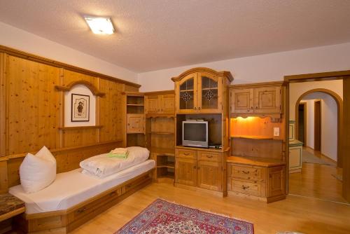 Una habitación grande con armarios de madera y un televisor. en Apart Auer Umhausen, en Umhausen