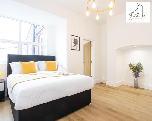 um quarto com uma cama grande e almofadas amarelas em Apartment 2 - Beautiful 1 Bedroom Apartment Near Manchester em Worsley