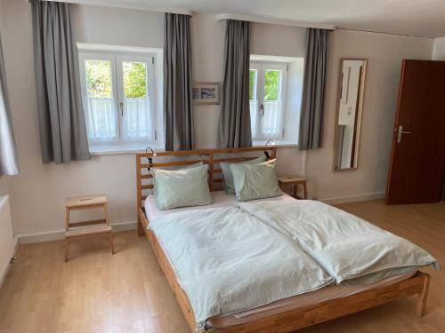 a bedroom with a bed and two windows at Ferienwohnung Wagnerhaus in Bad Reichenhall