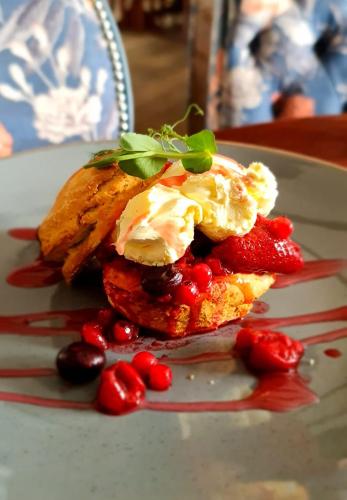 a plate with a dessert with strawberries and ice cream at The Black Swan in Glazebrook