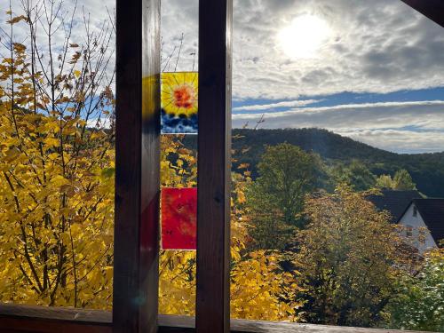 a stained glass window with a view of the mountains at Zur Glashütte Landpension in Fabrikschleichach