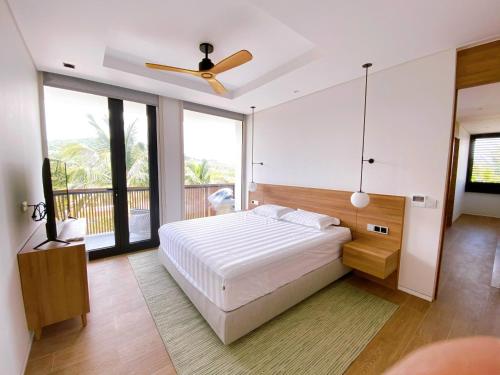 - une chambre avec un lit et un ventilateur de plafond dans l'établissement Phoenix Pool Villa Phu Quoc, à Duong Dong