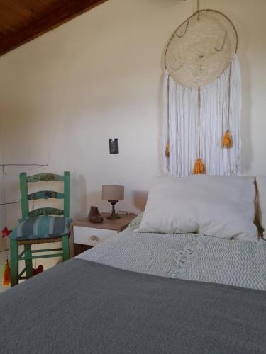 um quarto com uma cama e uma cadeira verde em Casuarinas em La Estafeta