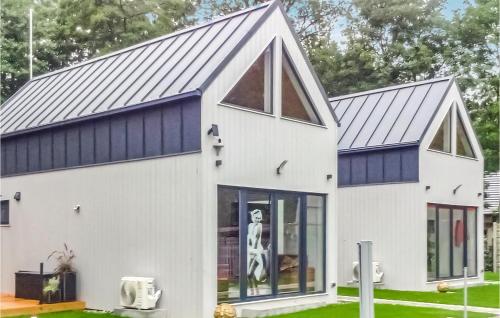 a white house with a blue roof at Awesome Home In Wilcze With Sauna in Wilcze