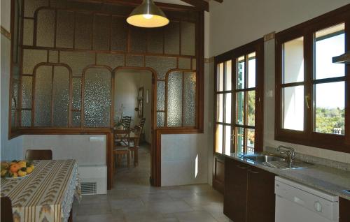 a kitchen with a table and a sink and windows at Cozy Home In Llub With Wifi in Llubí