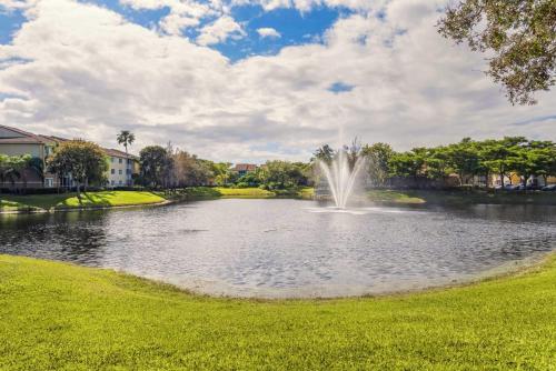 einen Brunnen in einem Teich in einem Park in der Unterkunft Luxurious Apartments with Pool and Gym at Boynton Beach in Boynton Beach