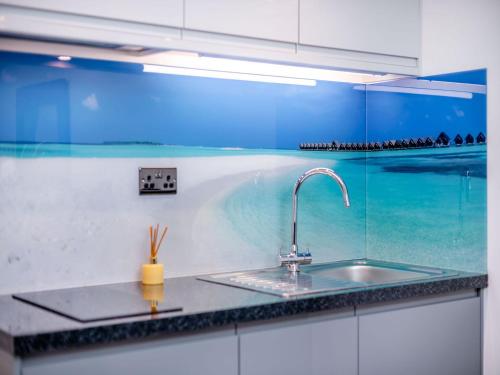 a kitchen counter with a sink and a glass wall at Little Heron - Uk40928 in Holdenhurst