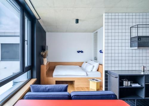 Habitación pequeña con cama y sofá en STAYERY Köln Ehrenfeld en Colonia