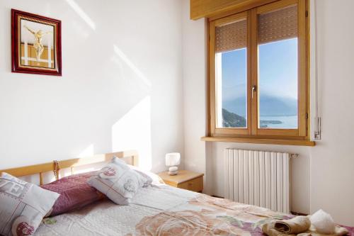 - une chambre avec un grand lit et une fenêtre dans l'établissement Casa Suono del Sole, à Consiglio di Rumo
