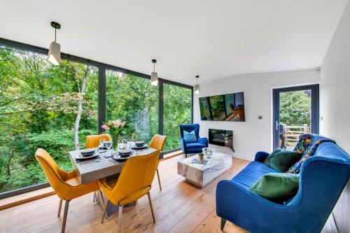 Finest Retreats - Luxurious Hidden Cragg Vale Escape by Hebden Beck في هيبدين بريدج: غرفة معيشة مع أريكة زرقاء وكراسي صفراء