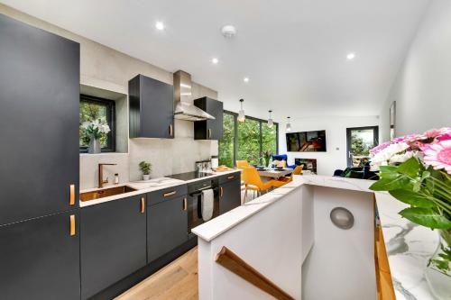 une cuisine avec des placards gris et une salle à manger dans l'établissement Finest Retreats - Luxurious Hidden Cragg Vale Escape by Hebden Beck, à Hebden Bridge