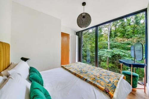 a bedroom with a bed and a large window at Finest Retreats - Luxurious Hidden Cragg Vale Escape by Hebden Beck in Hebden Bridge