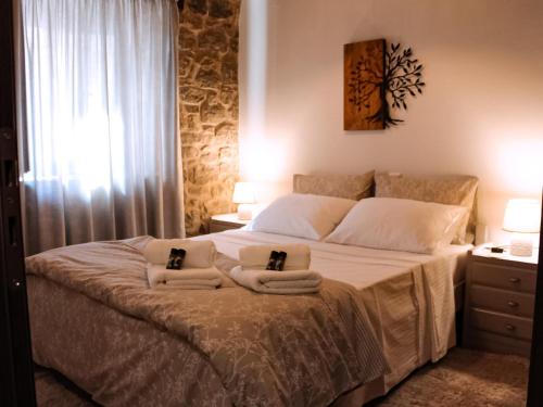 1 dormitorio con 1 cama con toallas en Αντίρρινο - Guest house, en Arachova