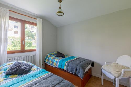 - une chambre avec 2 lits et une fenêtre dans l'établissement Chalet Les Tourelles, à Aix-les-Bains