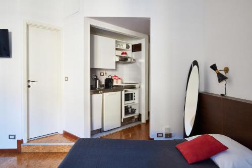 ミラノにあるStellar 70 Style Studio with Terrace-Heart of Milanのベッドルーム1室(ベッド1台付)、小さなキッチンが備わります。