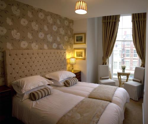 a bedroom with a large bed with two pillows at The Georgian Town House Hotel in Liverpool