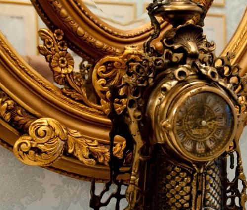 a gold clock in front of a mirror at The Georgian Town House Hotel in Liverpool