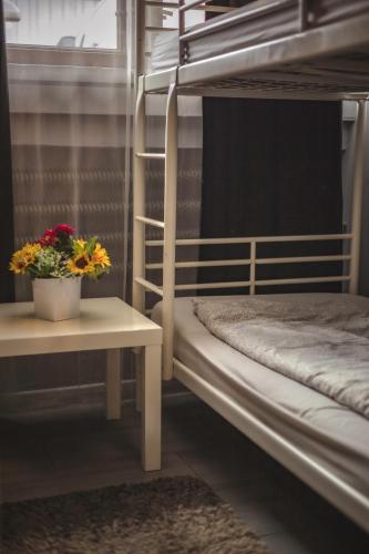 a room with two bunk beds with flowers on a table at 4 Couples & 4 Friends Hostel in Krakow