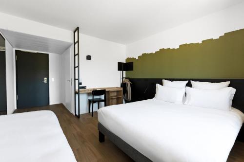 ジュネーヴにあるB&B HOTEL Geneva Airportのベッド2台とデスクが備わるホテルルームです。