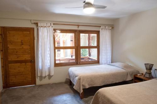 a bedroom with two beds and a window at Las Olas in Máncora