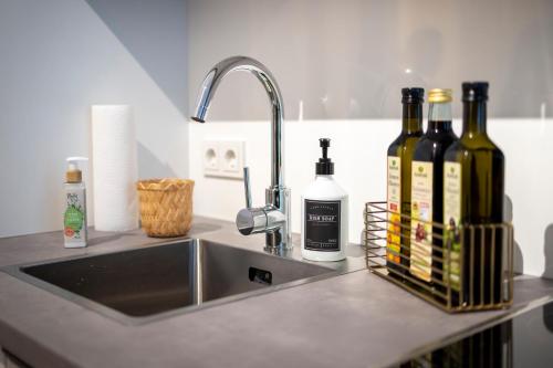 a kitchen counter with a sink and bottles of wine at Pure Berlin Apartments - Luxury at Pure Living in City Center in Berlin