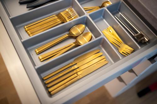 a drawer filled with gold utensils and forks at Pure Berlin Apartments - Luxury at Pure Living in City Center in Berlin