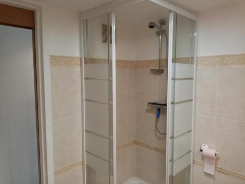 a shower with a glass door in a bathroom at Chambre calme en correze in Sainte-Fortunade