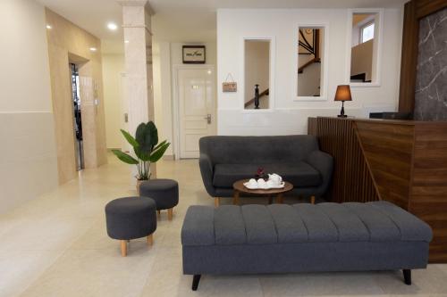 uma sala de estar com um sofá, uma mesa e cadeiras em Dalat Blanc Hotel & Apartment em Da Thanh