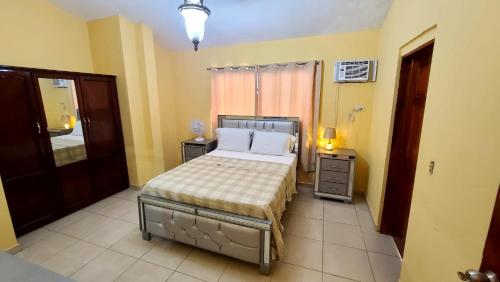 a bedroom with a bed in a room with yellow walls at Beautiful one bedroom penthouse suite 