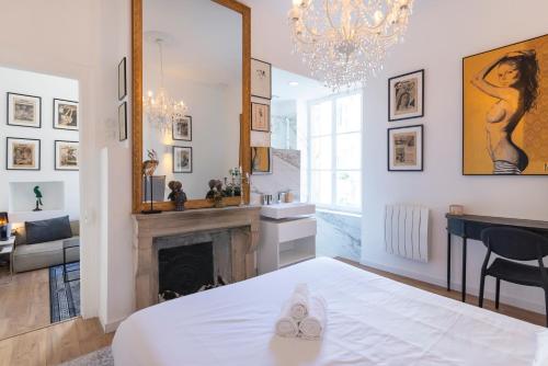 a room with a fireplace and a bed with a mirror at Le précieux de Nicolas in Nancy