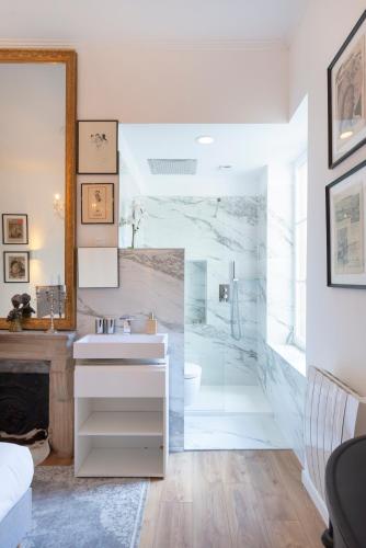 une salle de bain avec un lavabo blanc et une douche dans l'établissement Le précieux de Nicolas, à Nancy