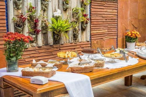 a wooden table with baskets of food on it at Carlton Plaza Baobá in Taubaté