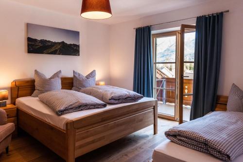 a bedroom with two beds and a window at Ferienwohnungen Anton Geierstanger in Wallgau