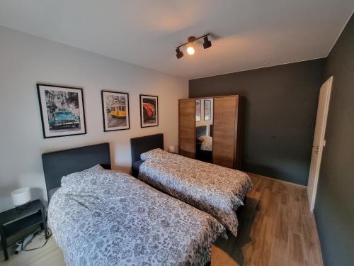 1 dormitorio con 2 camas en una habitación en Appartement cosy et familial avec terrasse en Theux