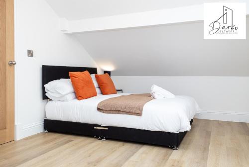 1 dormitorio con 1 cama con almohadas de color naranja en Apartment 5 - Beautiful 1 Bedroom Apartment Near Manchester, en Worsley