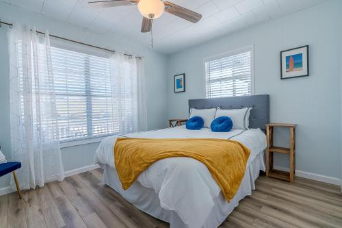 a bedroom with a bed with two blue pillows on it at NEW updated home w/ firepit, 2 min walk to beach in Surfside Beach