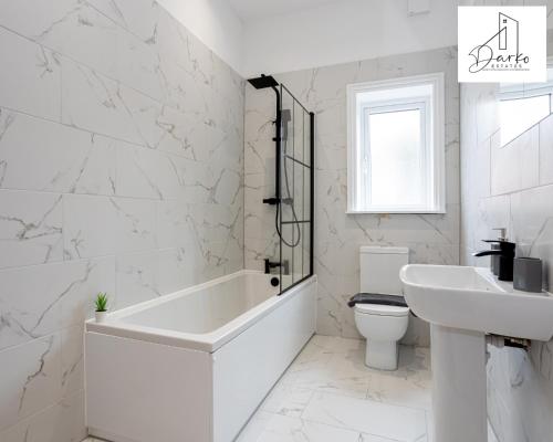 a bathroom with a tub and a toilet and a sink at Apartment 1 - Beautiful 1 Bedroom Apartment Near Manchester in Worsley