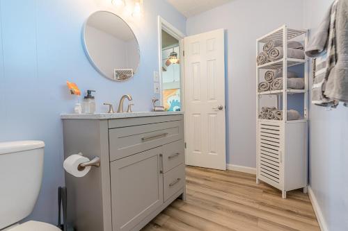 La salle de bains est pourvue d'un lavabo, d'un miroir et de toilettes. dans l'établissement NEW updated home w/ firepit, 2 min walk to beach, à Surfside Beach