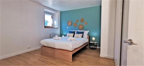 a bedroom with a bed with a blue wall at LA FERMETTE - Wifi - Parking - Netflix - Disney+ in Saint-Jorioz