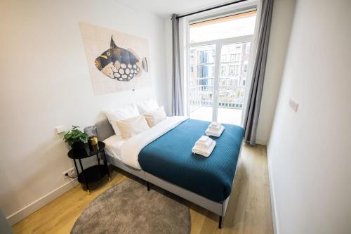 a bedroom with a bed and a large window at Cheerfully 1 Bedroom Serviced Apartment 52m2 -NB306C- in Rotterdam
