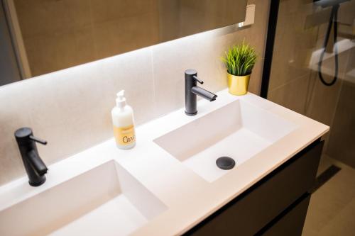 a white bathroom sink with a soap bottle on it at Cheerfully 1 Bedroom Serviced Apartment 52m2 -NB306C- in Rotterdam