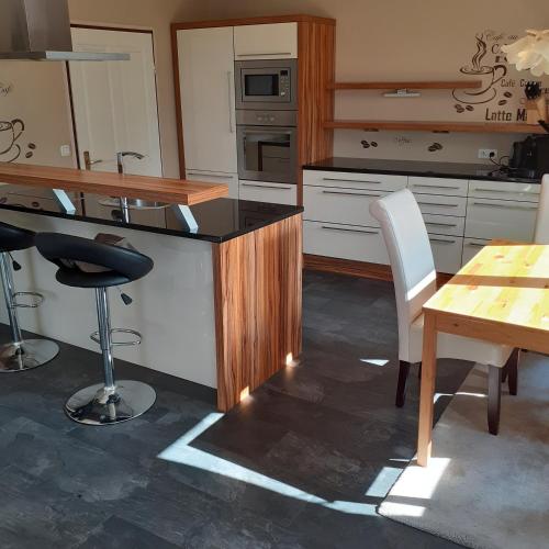 a kitchen with a wooden counter and a table and chairs at Reitbergs Nest in Eugendorf