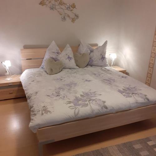 a bedroom with a bed with purple flowers and pillows at Reitbergs Nest in Eugendorf