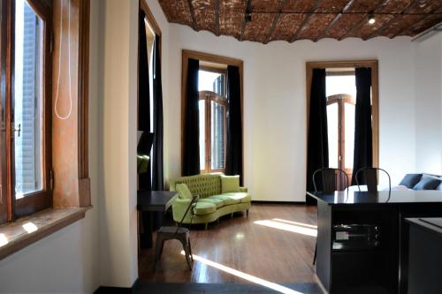 un soggiorno con divano verde e finestre di Departamentos Boulevard Caseros a Buenos Aires