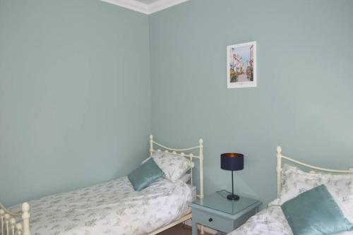 a bedroom with a bed and a table with a lamp at Victoria Lodge Woodhall Spa in Woodhall Spa