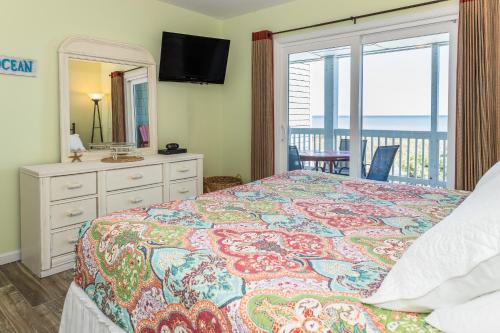 a bedroom with a bed with a view of the ocean at 2B at the Beach in Carolina Beach