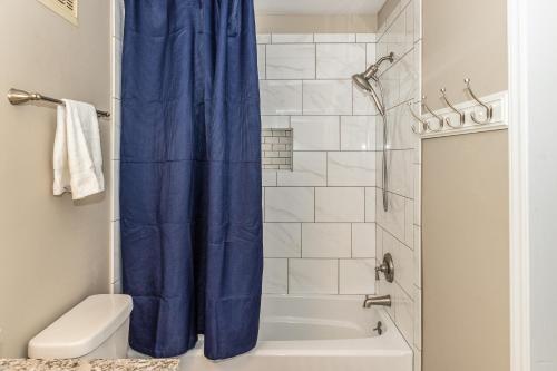 a bathroom with a shower with a blue shower curtain at 2B at the Beach in Carolina Beach