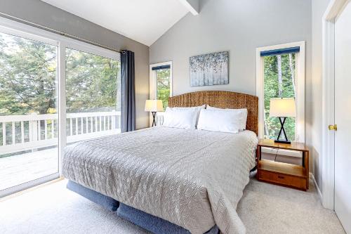 um quarto com uma cama grande e 2 janelas em Beautiful Four Season Mountain Retreat em Campton