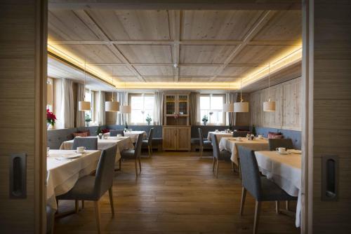 レッヒにあるHotel Garni Panoramaの部屋にテーブルと椅子があるレストラン